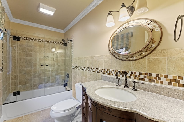 full bathroom with combined bath / shower with glass door, toilet, tile walls, and crown molding