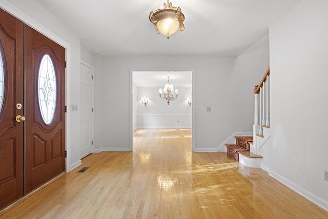 entryway with light hardwood / wood-style flooring and a notable chandelier