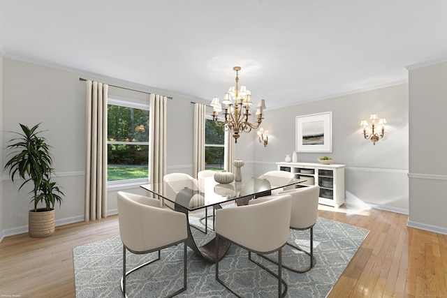 dining room with light hardwood / wood-style floors, ornamental molding, and an inviting chandelier