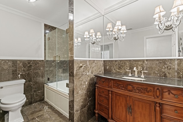 full bathroom featuring vanity, shower / bath combination with glass door, toilet, ornamental molding, and tile walls