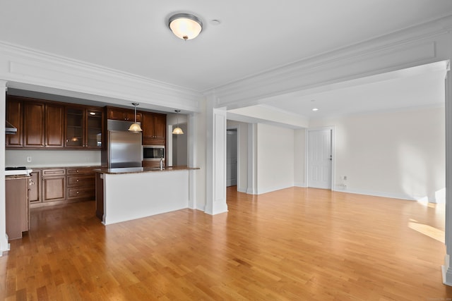 kitchen with light wood-type flooring, dark brown cabinetry, pendant lighting, built in appliances, and ornamental molding