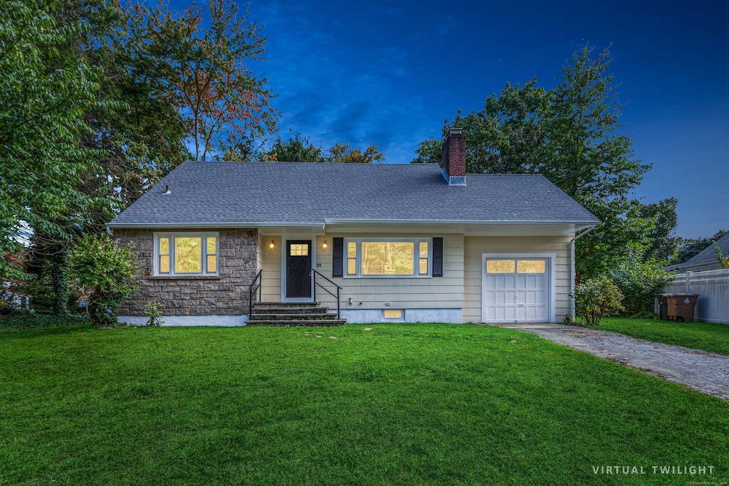 ranch-style home with a garage and a lawn