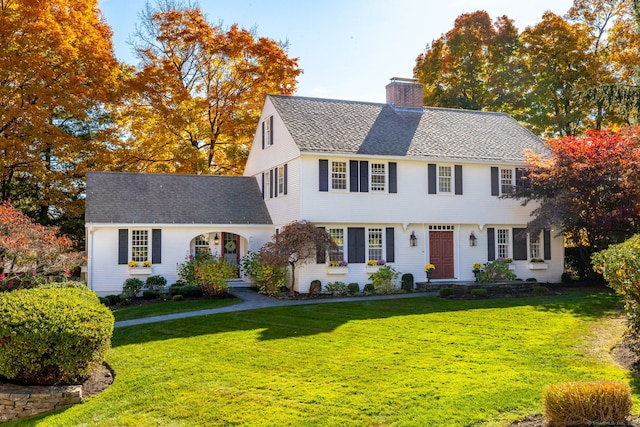 colonial inspired home featuring a front lawn