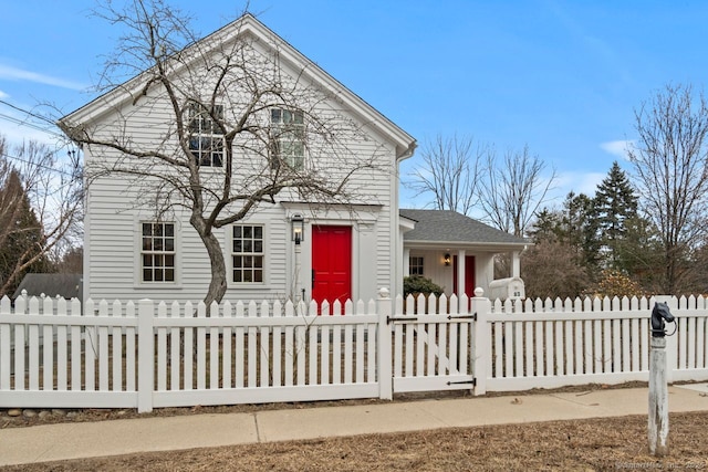 view of front of property featuring a fenced front yard and a shingled roof