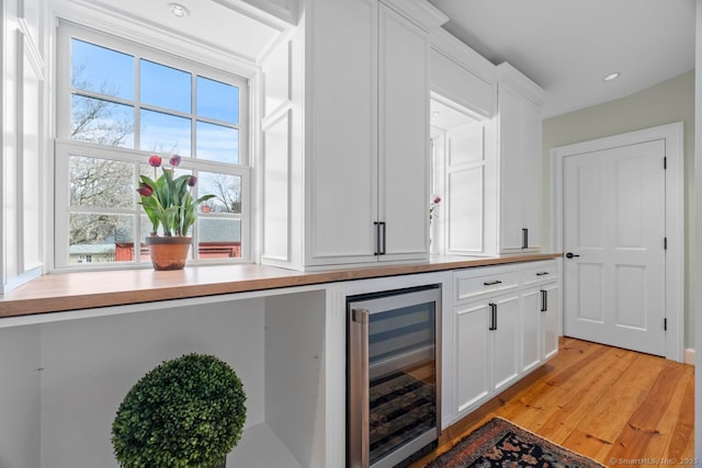 bar featuring wine cooler, recessed lighting, and light wood-type flooring