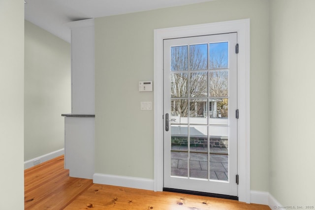 doorway to outside featuring wood finished floors and baseboards