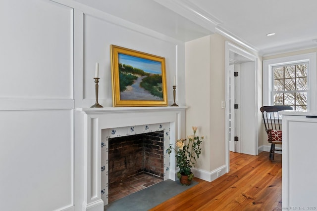 unfurnished living room with baseboards, wood finished floors, and a fireplace