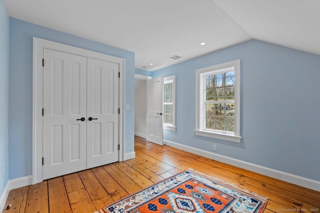 unfurnished bedroom with a closet, baseboards, and hardwood / wood-style floors