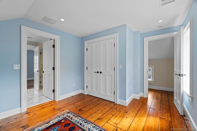 unfurnished bedroom with a closet, visible vents, and light wood finished floors