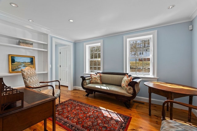 sitting room with crown molding, recessed lighting, wood finished floors, and baseboards