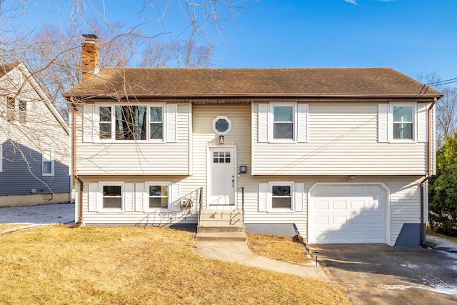 raised ranch with a front yard and a garage