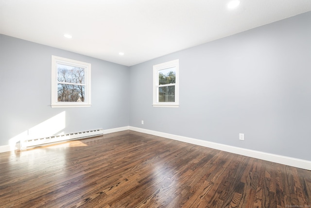 unfurnished room featuring dark hardwood / wood-style flooring and a baseboard heating unit