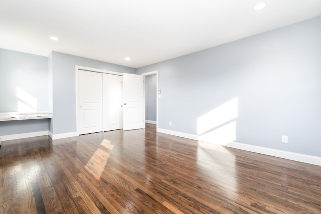 unfurnished bedroom featuring dark hardwood / wood-style floors and a closet