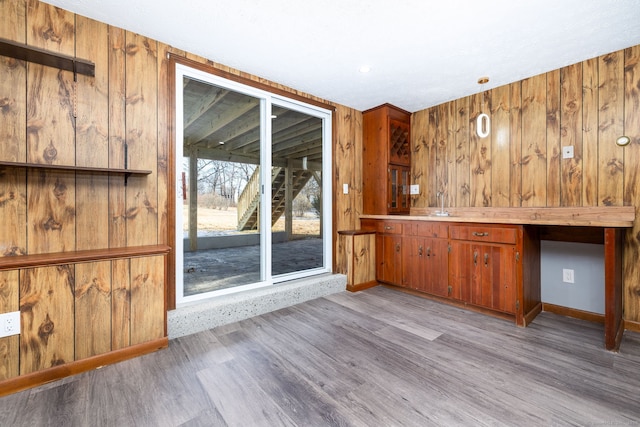 bar with wood walls, light wood-type flooring, and sink