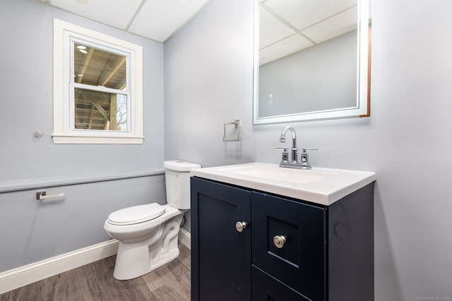 bathroom with vanity, hardwood / wood-style floors, a paneled ceiling, and toilet