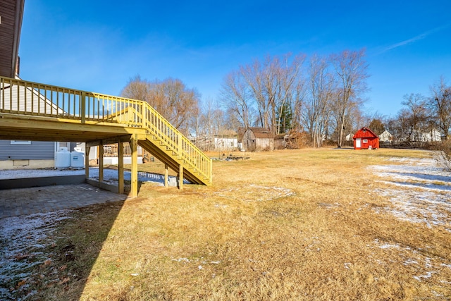 view of yard featuring a wooden deck and a shed