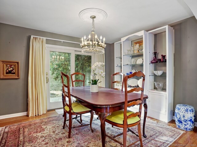 201 Shore Rd, Greenwich, CT 06830 - dining area with a chandelier, light wood-type flooring, and baseboards