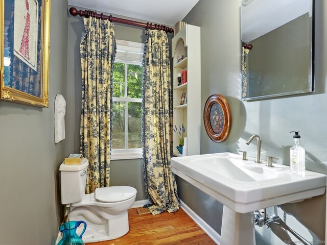 201 Shore Rd, Greenwich, CT 06830 - bathroom with toilet, wood finished floors, a sink, and baseboards