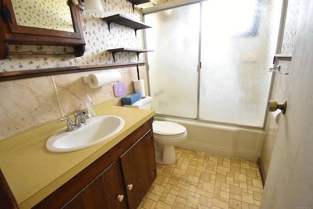 full bathroom featuring shower / bath combination with glass door, vanity, and toilet