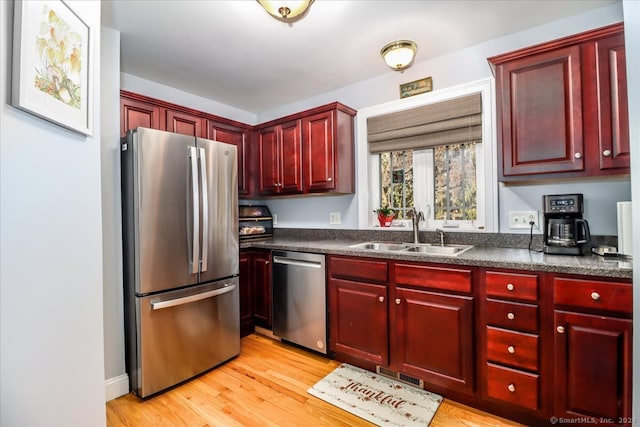 kitchen featuring appliances with stainless steel finishes, light hardwood / wood-style flooring, and sink