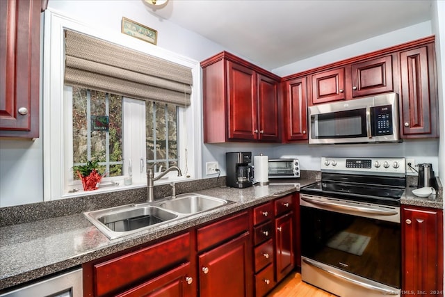 kitchen featuring sink, appliances with stainless steel finishes, and light wood-type flooring