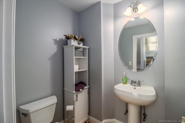 bathroom with toilet and a notable chandelier