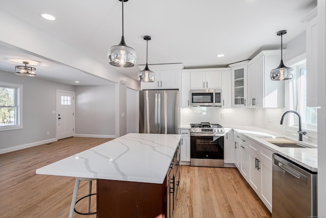 kitchen with a center island, white cabinetry, sink, and appliances with stainless steel finishes