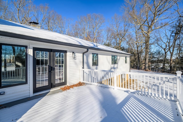 snow covered deck with french doors