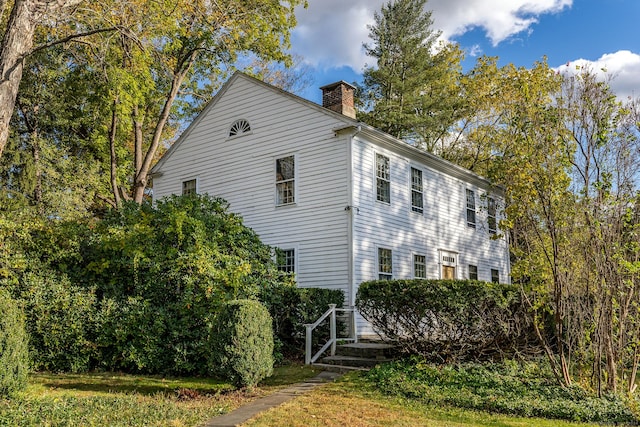 view of property exterior with a chimney