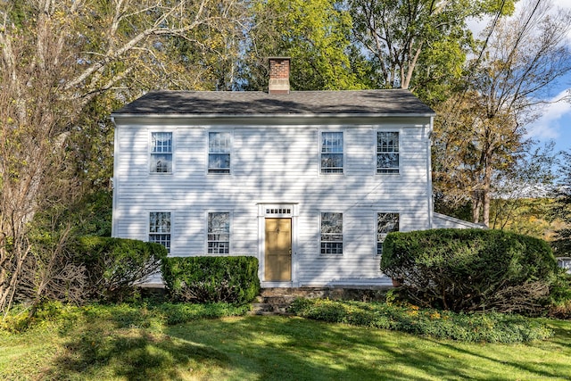 view of front of house with a front yard and a chimney