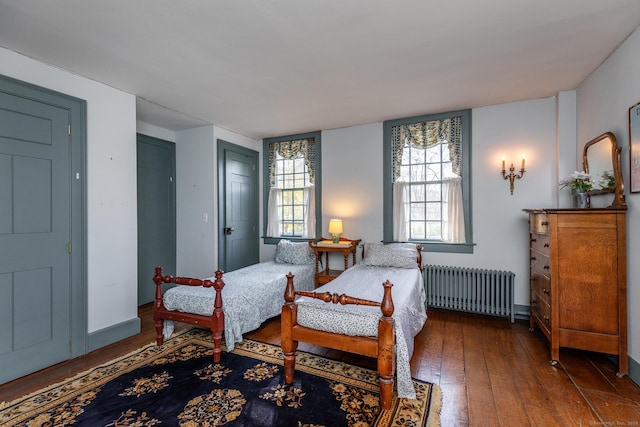 sitting room with radiator, baseboards, and hardwood / wood-style flooring