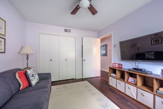 living room with dark hardwood / wood-style floors and ceiling fan