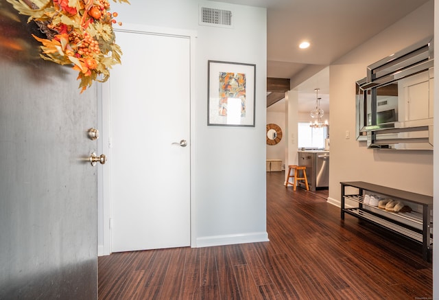 hallway with a chandelier and dark hardwood / wood-style flooring