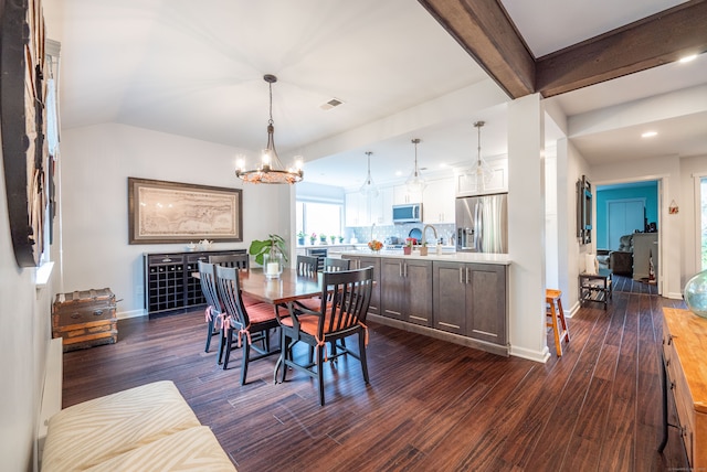 dining space with a notable chandelier, dark hardwood / wood-style floors, and beam ceiling