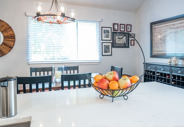 dining space featuring a healthy amount of sunlight, lofted ceiling, and a chandelier