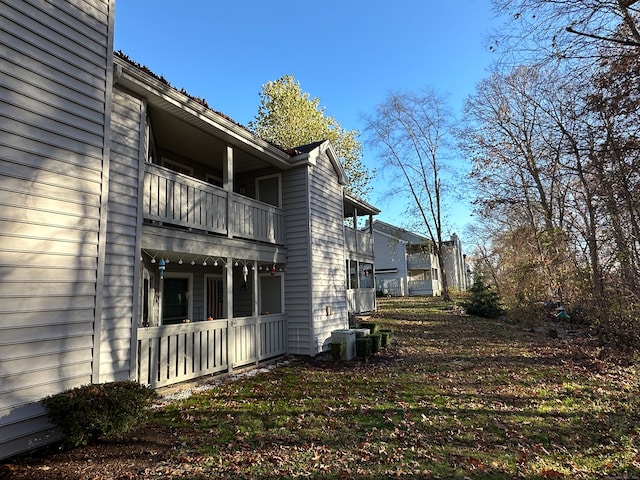 view of side of property with central AC and a balcony