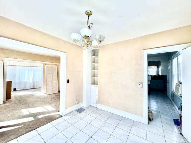 spare room with cooling unit, a chandelier, and light colored carpet