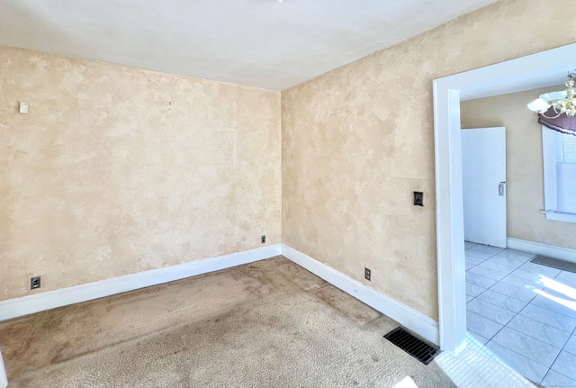 empty room featuring an inviting chandelier and carpet