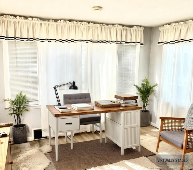 office area with a wealth of natural light and hardwood / wood-style floors