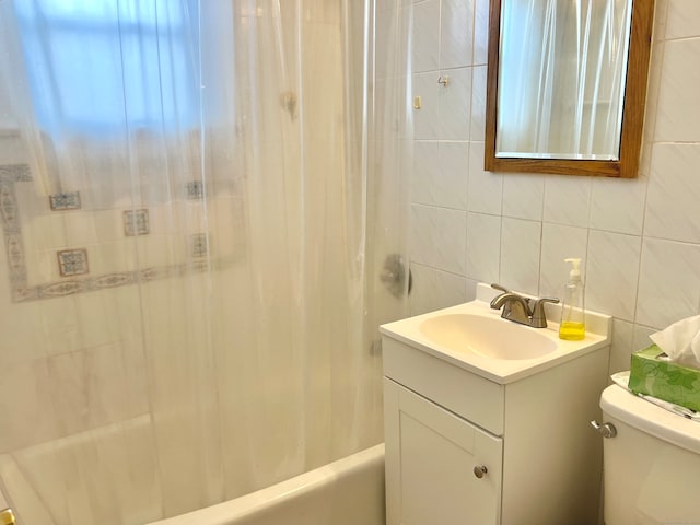 full bathroom with vanity, toilet, tile walls, and shower / tub combo