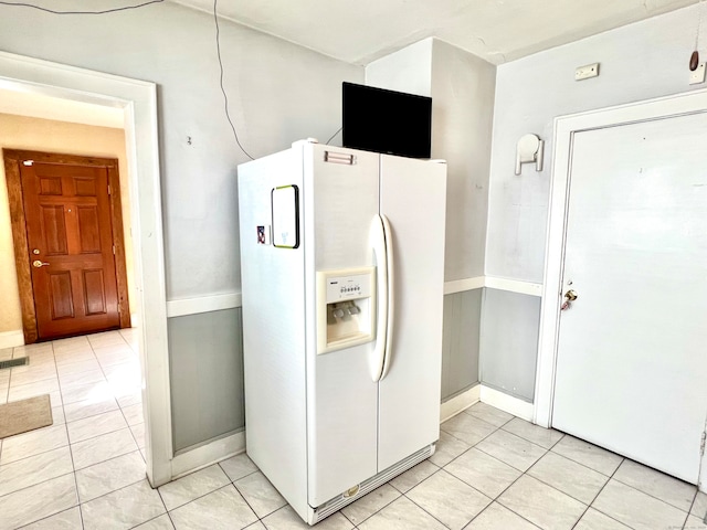 kitchen with white fridge with ice dispenser and light tile patterned floors