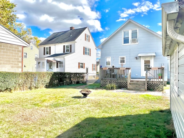 back of house featuring a wooden deck and a yard