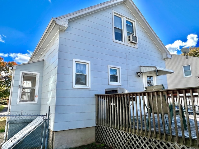 rear view of property with a wooden deck and cooling unit