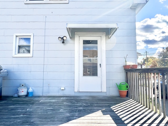 view of exterior entry featuring a wooden deck