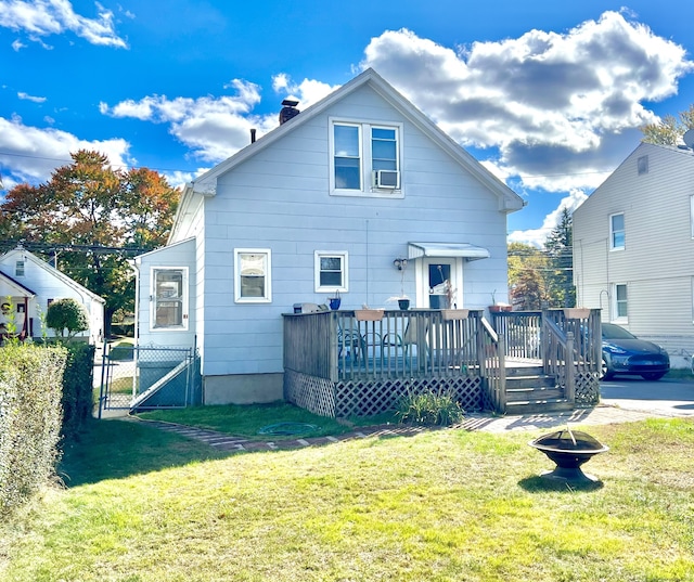 rear view of property with a wooden deck and a lawn