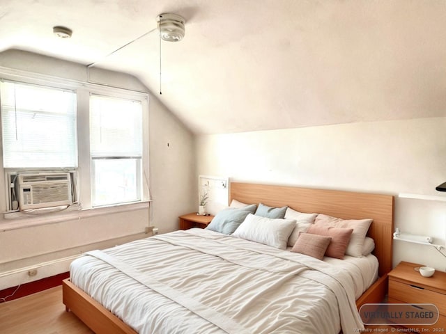 bedroom featuring hardwood / wood-style floors and vaulted ceiling