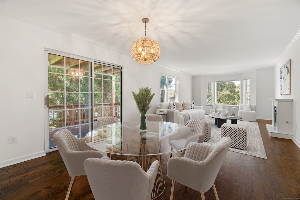 dining space featuring ornamental molding, dark wood-type flooring, and a chandelier