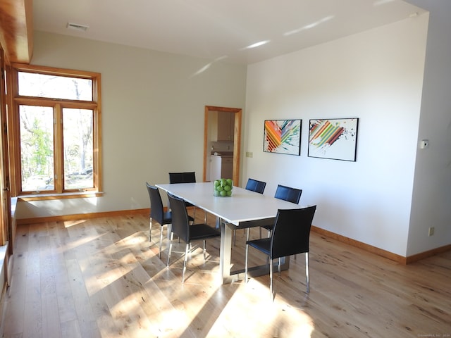 dining area with light wood-type flooring and washer / clothes dryer