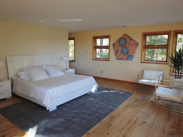 bedroom featuring light hardwood / wood-style floors and multiple windows