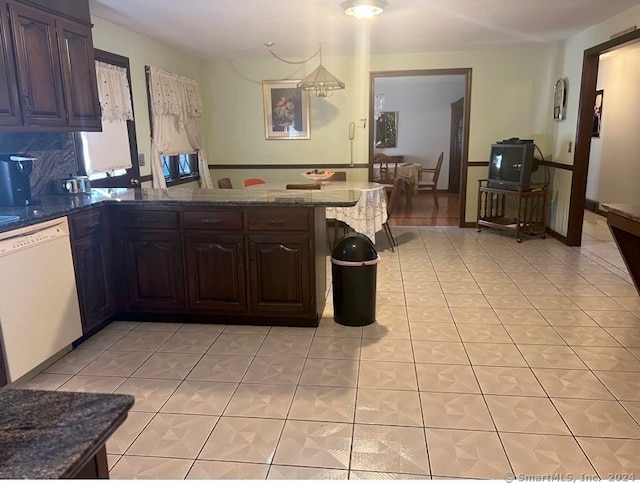 kitchen with dishwasher, kitchen peninsula, light tile patterned floors, and dark brown cabinets